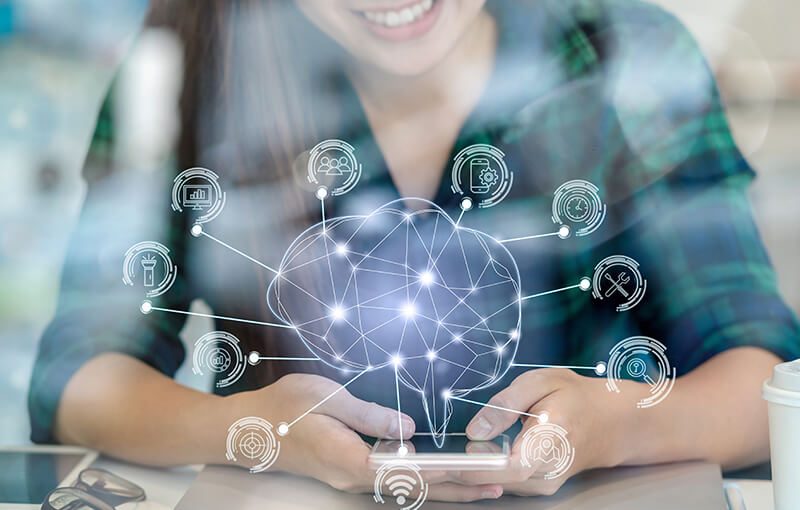 Someone holding a smartphone with a wire-frame brain overlaid and several lines coming off and pointing to various icons representing choices