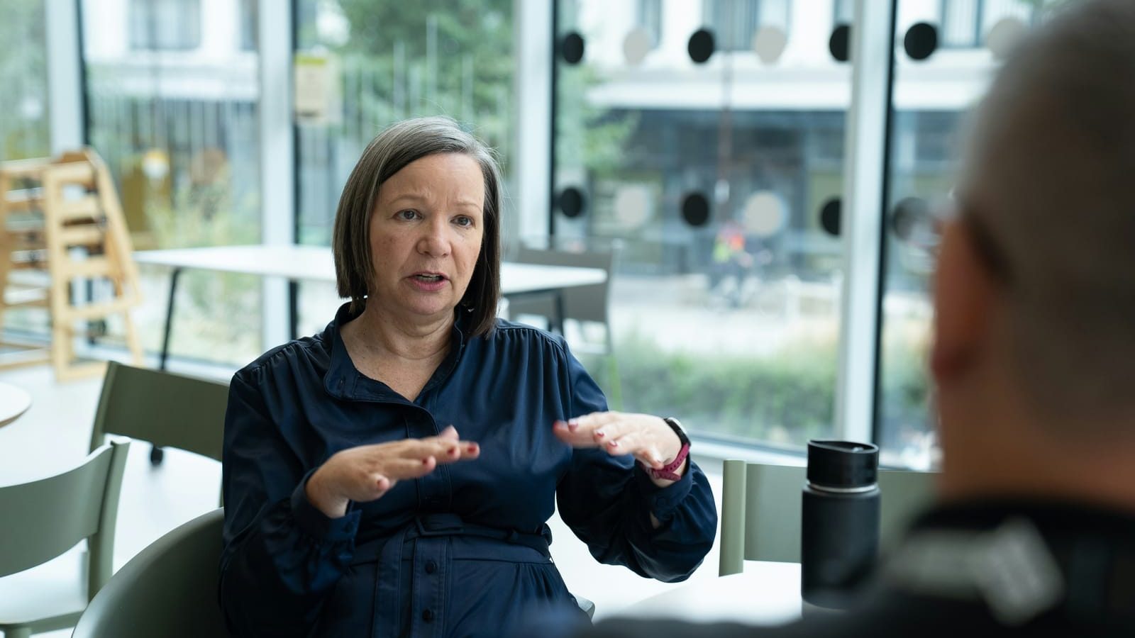 An experienced professional talks a colleague through something across a table.