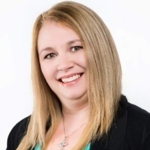 Smiling woman with shoulder-length blonde hair in a black blazer and teal blouse