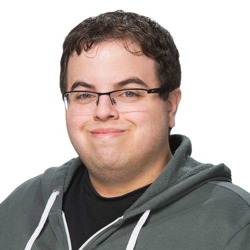 Stephen Skobel, with a slight smile and short brown hair, in a sage green zip-up sweater